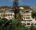 a view of Casa Higueras Chile from the outside with tiered whitel hotel style building on top of a small hill with trees all around