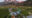 several green domes are located within Patagonian nature surrounded by mountains and trees,