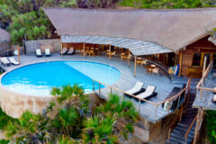 aerial view of a beach lodge with pool, lounge chairs in Mozambique