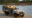 people on a game drive in a jeep by a lake with a ranger looking at the water
