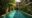 blue hotel pool with partial view of the 2 storey hotel with balconies looking out onto the pool. Surrounding the pool and climbing up the walls is lush greenery.