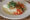 a plate with carrots, tomatoes, and a meal