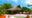 a day view of a wooden Iharana Bush Camp with lounge chairs, table and lush green forest surrounding