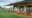 main tented building in the bush featuring two camp chairs, suported by wooden stilts all set in a green african bush