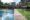 a partial view of an outdoor pool by lawn with concrete area