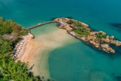 a view of an island resort stretching from the jungle into the ocean