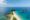 an aerial view of nacpan beach in el nido, philippines, shows a stretch of white sent with a clump of trees at the end going out into a blue sea and little boats are parked along one side of the sand