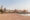 Sandy Beach at sunset with volleyball courts. In the background is a complex of buildings 3 storey high buildings which make up the Strand Hotel Swakopmund