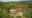 an aerial view of two bungalows set within jungle