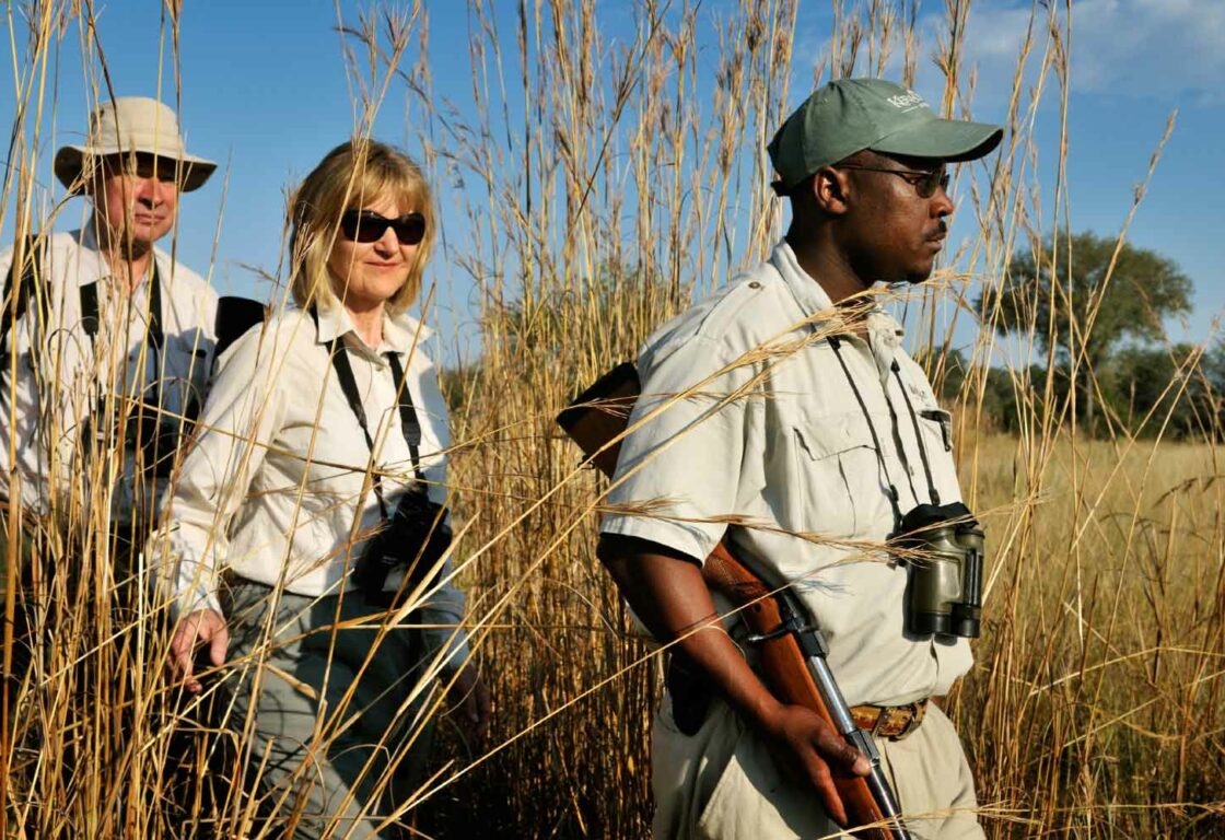 a couple and a safari guide on a walking safari in Botswana