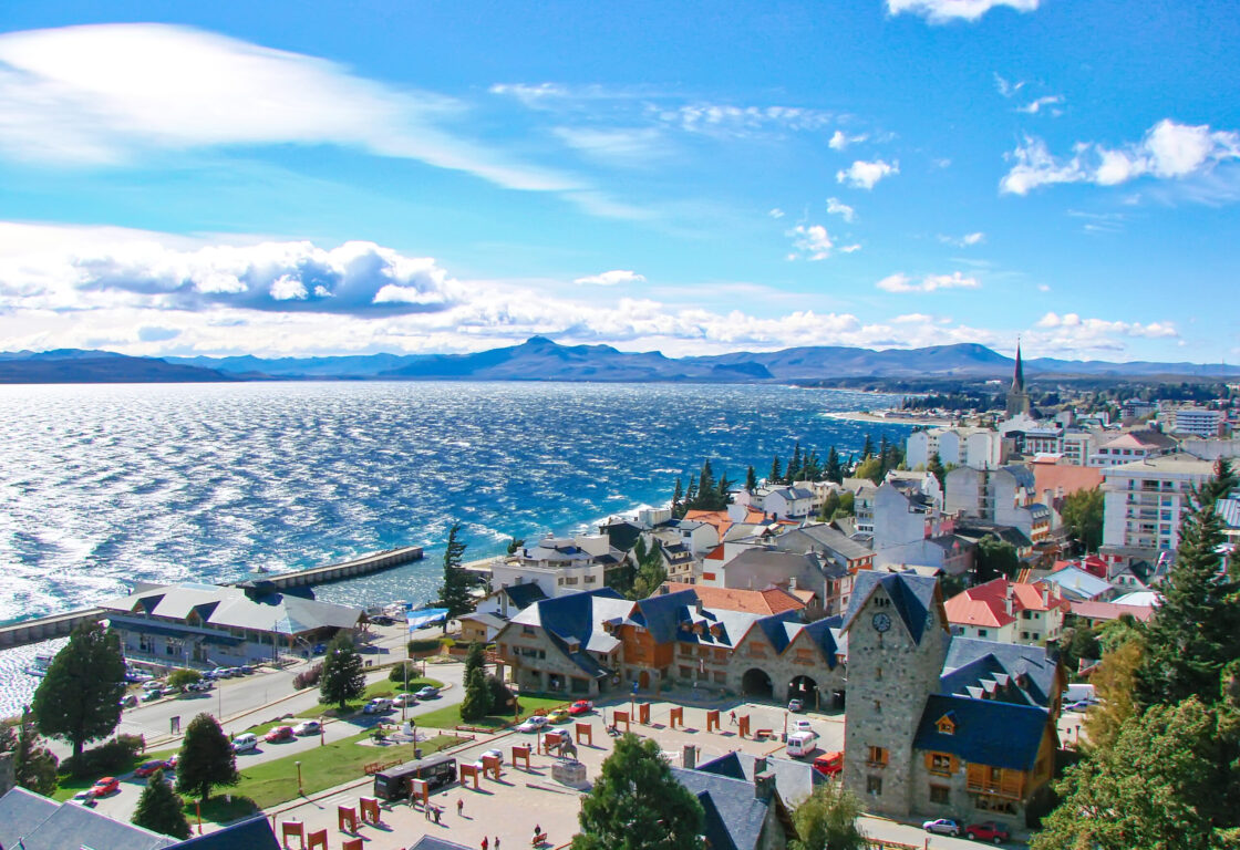 Aerial view of San Carlos de Bariloche, Argentina, showing the quay and municipal buildings with the lake and mountains in the background.