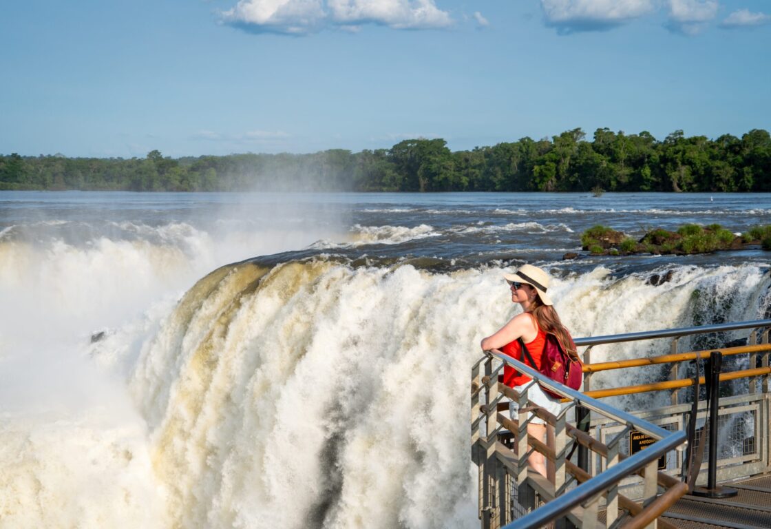 Woman looking out over Iguazu Falls from the a walkway on the Upper Circuit