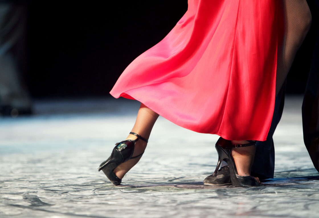 Close up of Tango dancers' feet with red skirt in motion, Buenos Aires