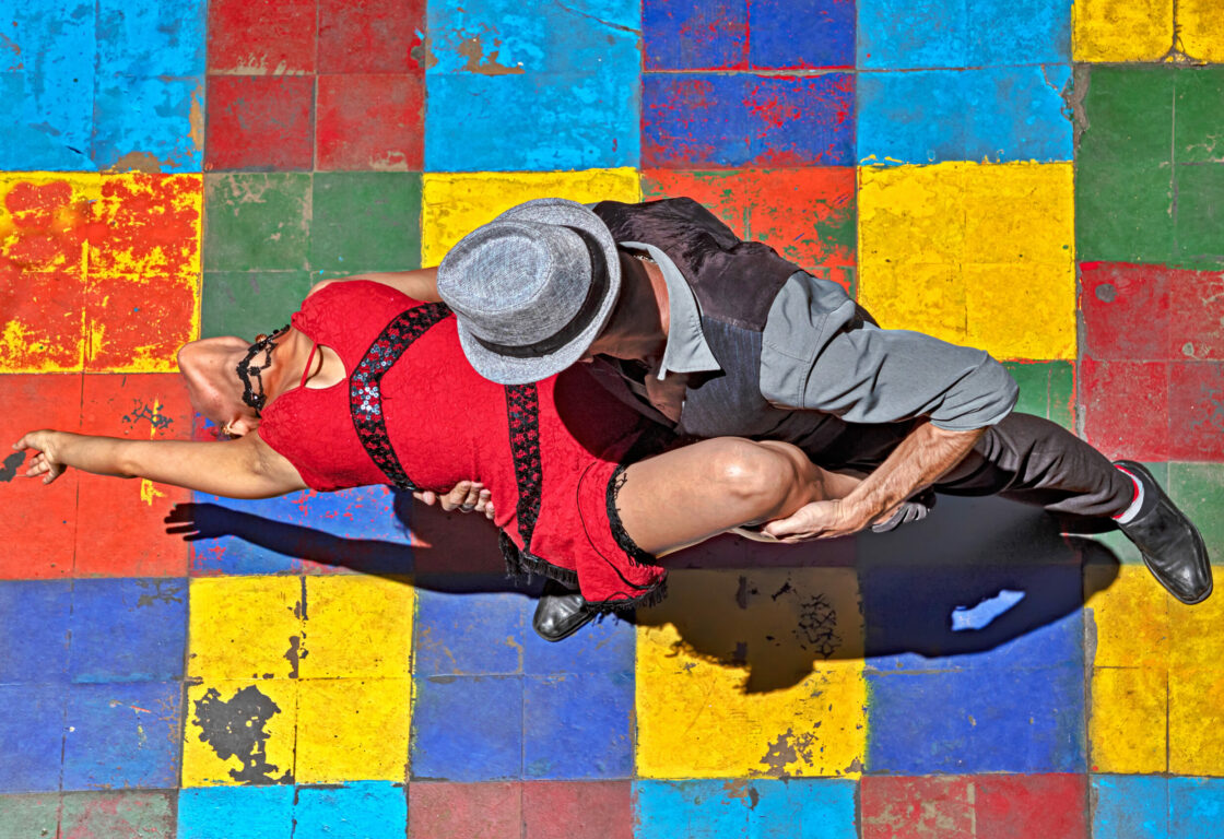 Tango dancers pictured from above on colourful floor tiles