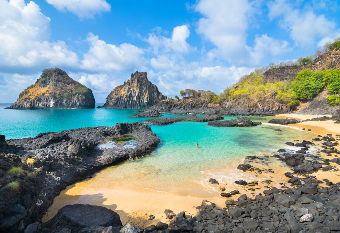 Angled shot of white sand and turquoise waters of Baia dos Porcos at Fernando de Noronha