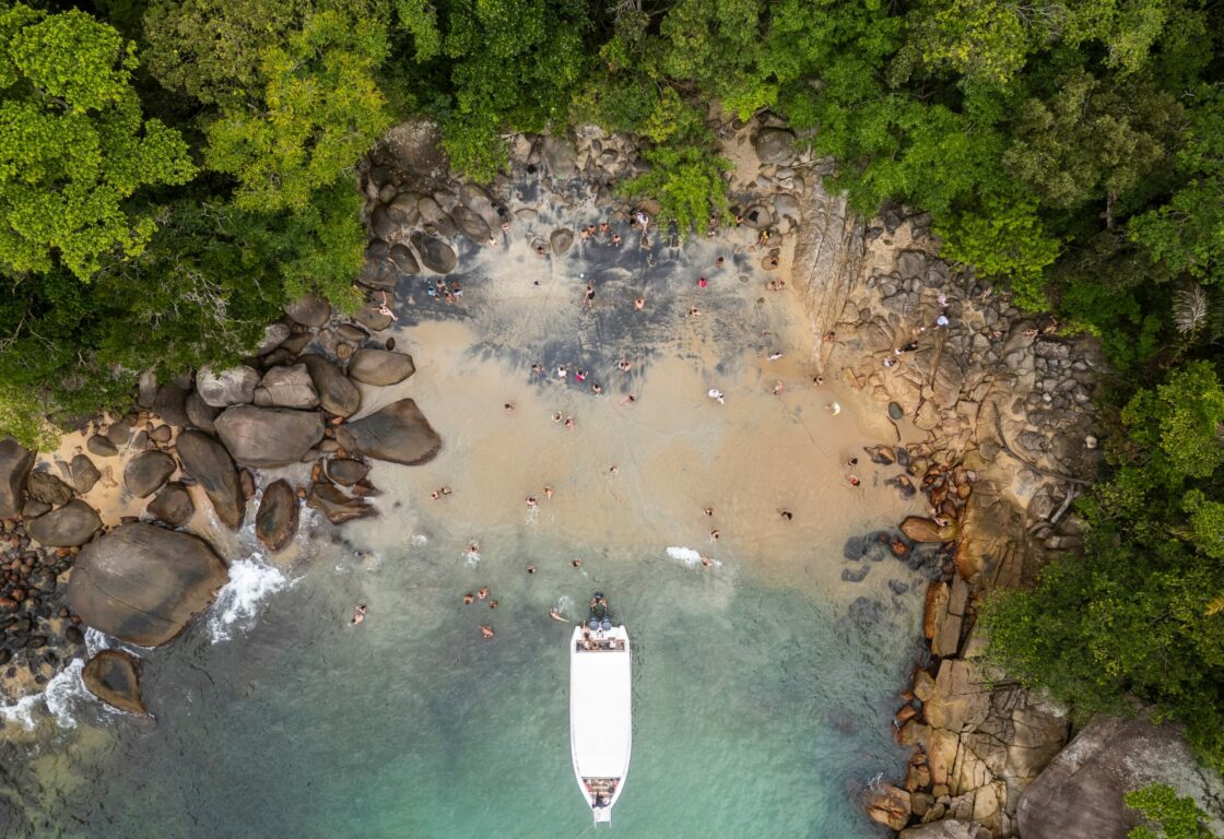 Aerial view of a sandy cove on Ilha Grande, with boat and swimmers
