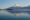 Cartoon-like picture perfect volcano with a snow covering its peak, in front of a peaceful lake