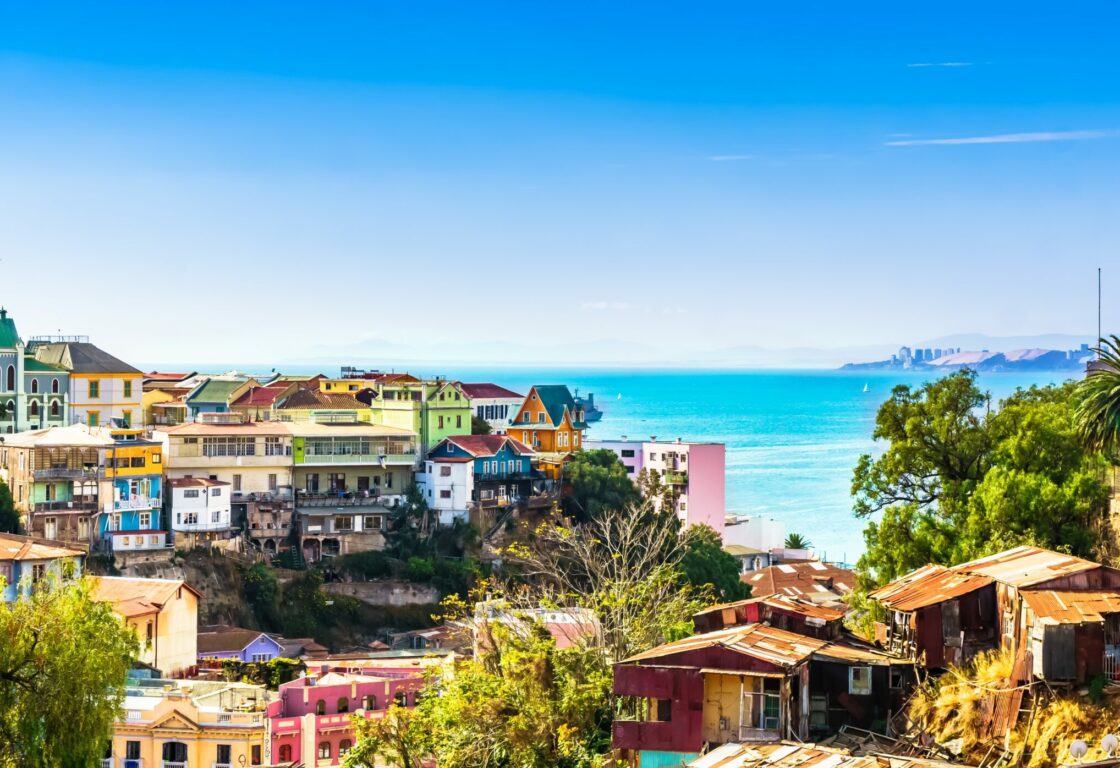 Panoramic shot of colourful houses on a hill, in a german style. In the background the sea, a brilliant blue.