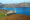 Taken from the summit of Bartolome Island, looking out at the rest of the island's volcanic structures, including pinnacle rock, a sharp, tall rock formation that juts out at the islands edge, looking out over the water.