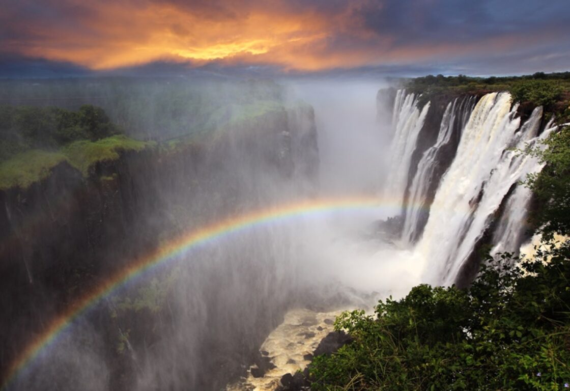 aerial shot of Victoria Falls at sunset with a rainbow reflection