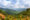 A wide shot of a lush green landscape with green rolling mountains