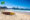 a yellow and brown surf board on it's side on a beach by the ocean - Copacabana beach, Brazil