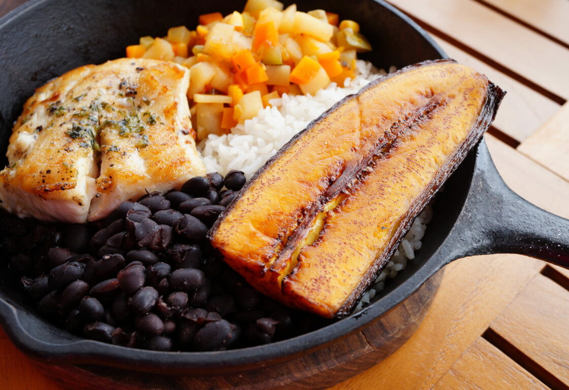 Traditional Costa Rican Casado meal with rice, beans, plantains and fish