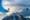 two condors flying high up with mountains as background