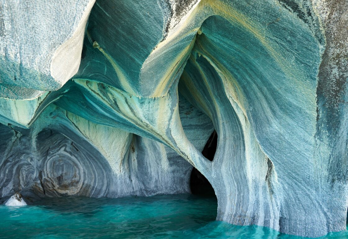 the curved smooth marble caves peaking above the water lever - Catedral de Mármol or Marble Chapels, Puerto Río Tranquilo, Patagonia, Chile
