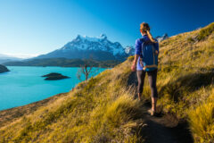 a woman dressed in hiking clothes with a little hat hiking W Trek to Lake of Torres del Paine National Park, Patagonia, Chilie