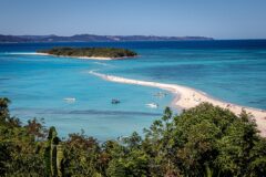 and aerial view of Nosy Iranja Island in Nosy Be, Madagascar with trees, long stretch of a sandy path in the ocean leading to a nearby island