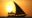 A traditional dhow silhouetted against the setting sun.