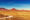 a landscape view of a dirt road through the vast savanah and rock formations in Damaraland Namibia
