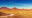 a landscape view of a dirt road through the vast savanah and rock formations in Damaraland Namibia