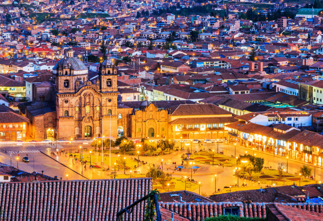 an aerial view of Cusco, Peru the historic capital of the Inca Empire. Plaza de Armas with lots of houses behind it at twilight.
