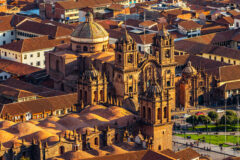 an aerial view of Cusco city in Peru with cathedrals and houses all around
