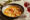 peri peri prawns served in a dish and two glasses of red wine