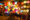 colourful lanterns in various colours and patterns and shapes are hung up at a stall and below them baskets sit on stools and on the floor are the shells of lanterns in a pile