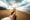 Happy and excited girl taking her boyfriend's hand while walking enjoying summer sunset at the beach - Traveler couple leads on vacation between the mountain - Follow me concept and traveling together
