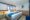 a view of a bedroom on a yacht with double bed, white and blue bedding, mirror on a wall with a dressing table and a small soft chair