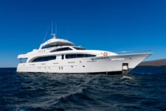 a view of a white yacht called Grand Majestic, floating on the sea in Galapagos