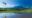 Tropical landscape in Borneo with palm trees, wetlands and mountains in the distance.